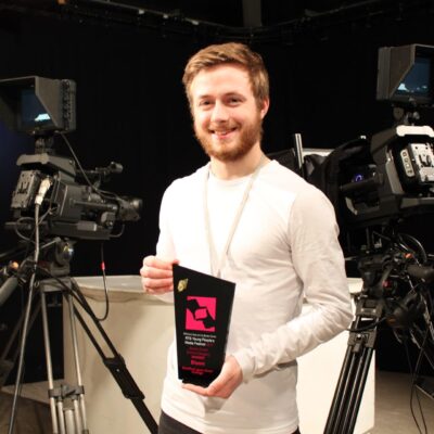 Alexander Eves proudly holding his award in Stratford-upon-College’s television studio.