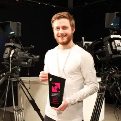 Alexander Eves proudly holding his award in Stratford-upon-College’s television studio.