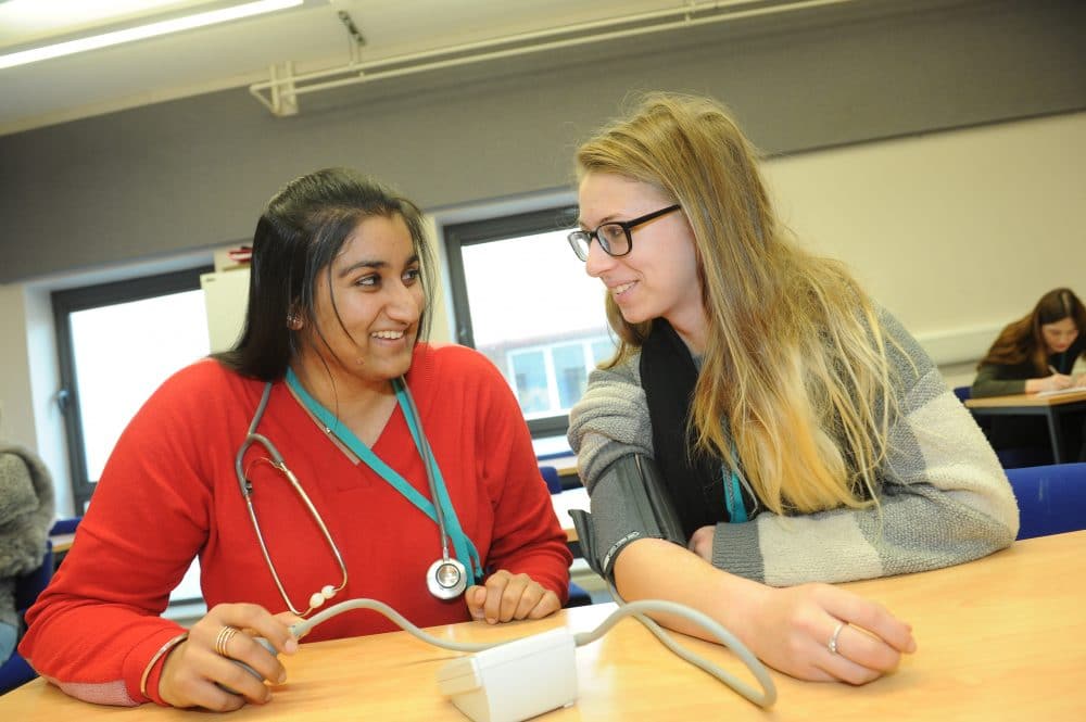 heath and social care students testing blood pressure