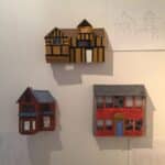 Photograph of 3 mounted 3d models of buildings.