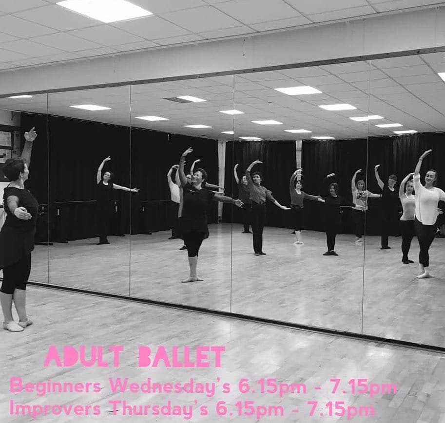 Ballet dancers practicing in front of a mirror.