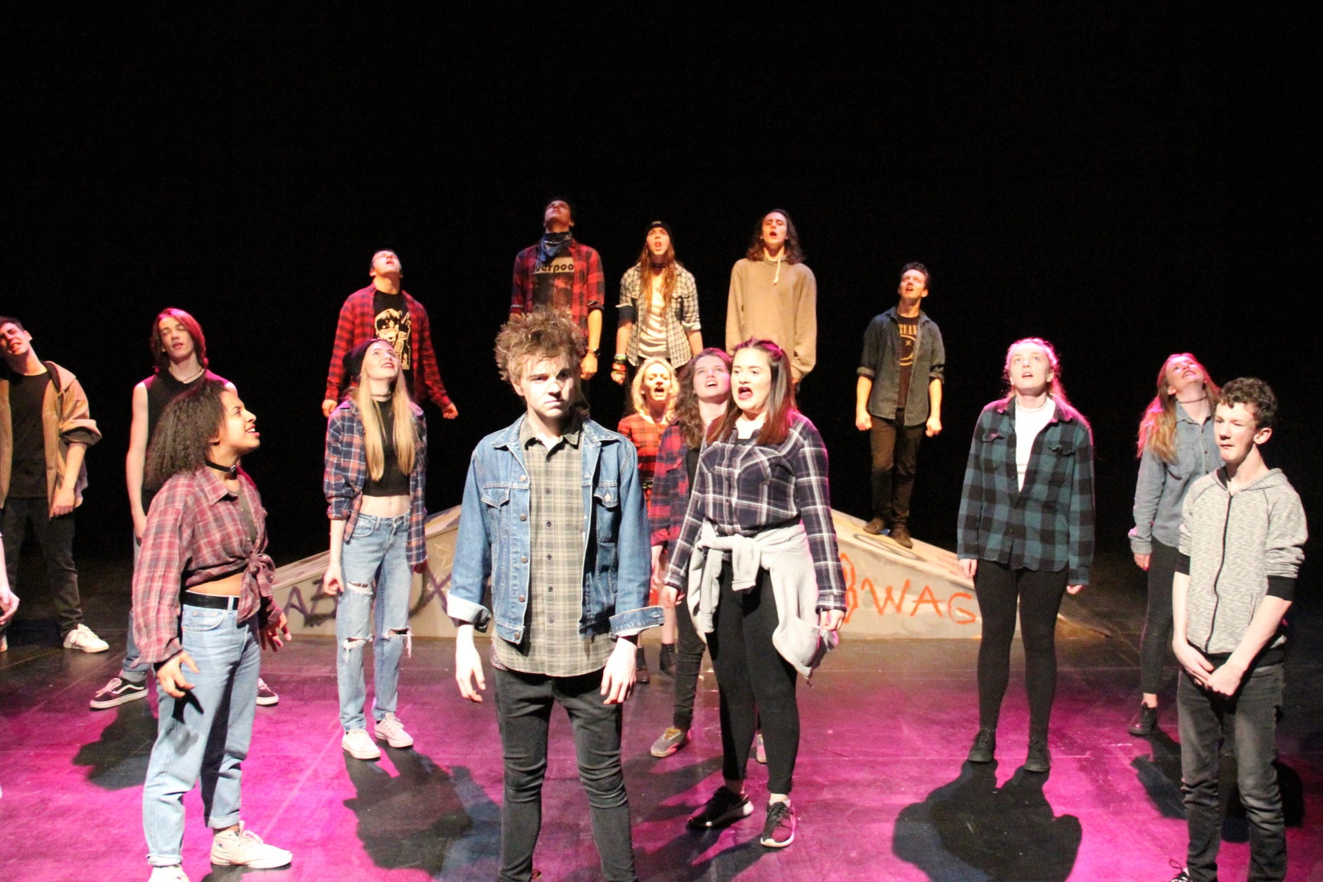 students singing and acting on a theatre stage