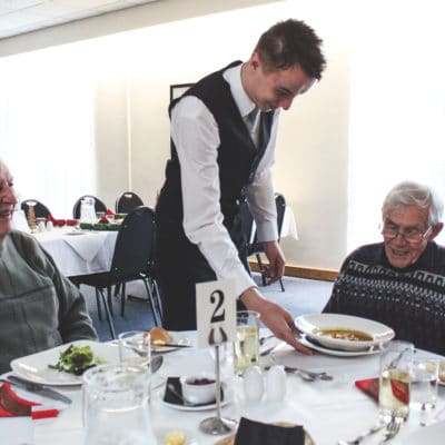 Student serves at Friendship Lunch Club