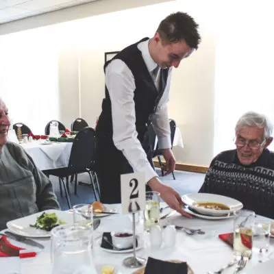 Student serves at Friendship Lunch Club