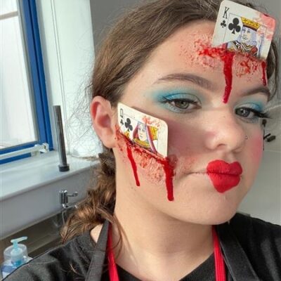 Student face make up with two poker cards on face