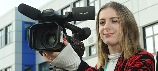 student holding a camera with right hand