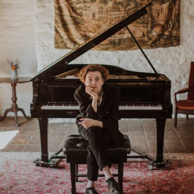 Student sitting in front of piano with legs crossed