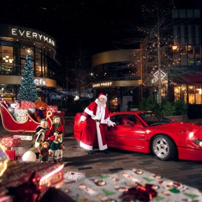 Santa standing in front of a ferrari
