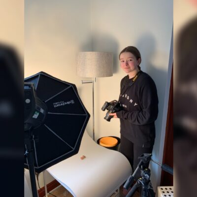 Charlie holding camera in her home studio