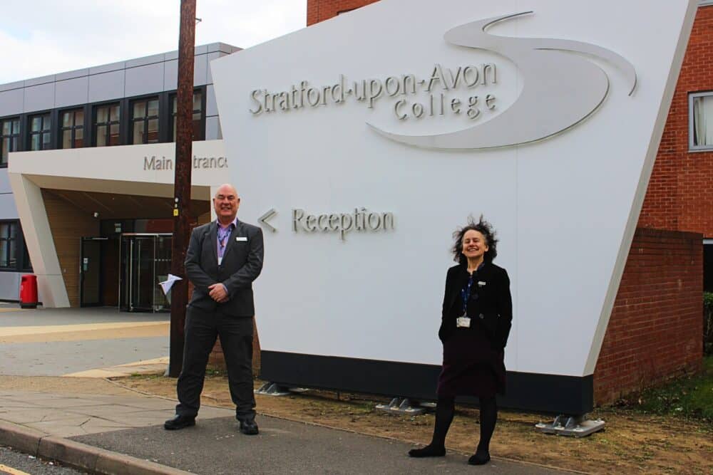 Principals standing in front of Stratford-upon-Avon College Reception sign