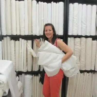 Louisa in front of rolls of white fabric