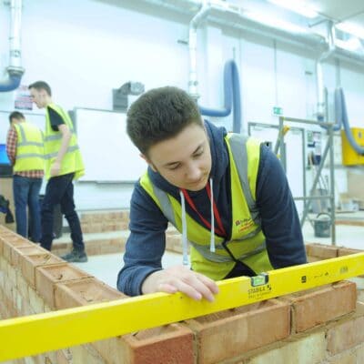 Student measuring brick wall at Stratford-Upon-Avon College