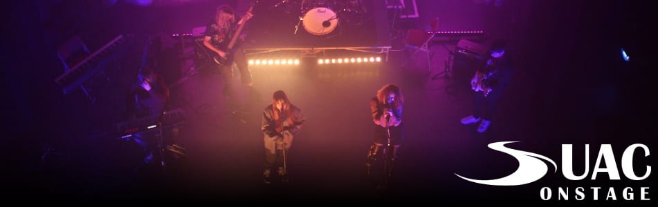 Two singers perform with a band