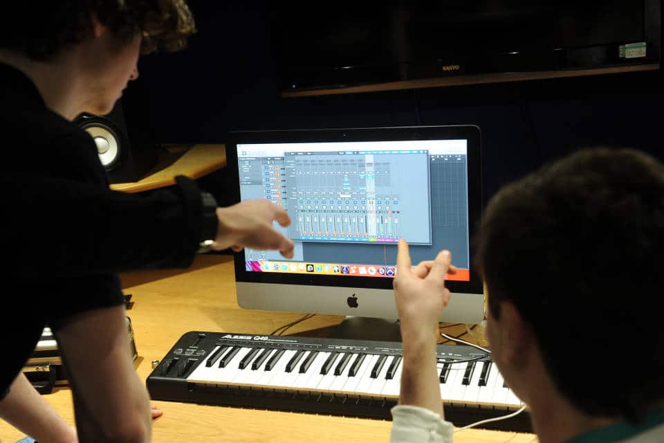 music production students with keyboard and apple computer