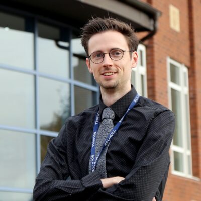 apprentice standing with arms crossed at Stratford-Upon-Avon College