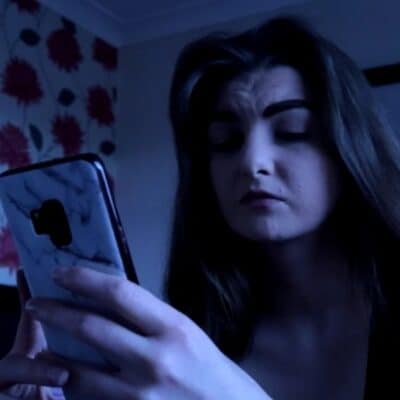 Scared woman looking at her mobile phone