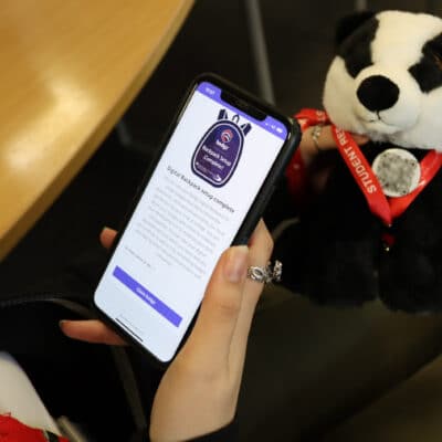Badger with student phone