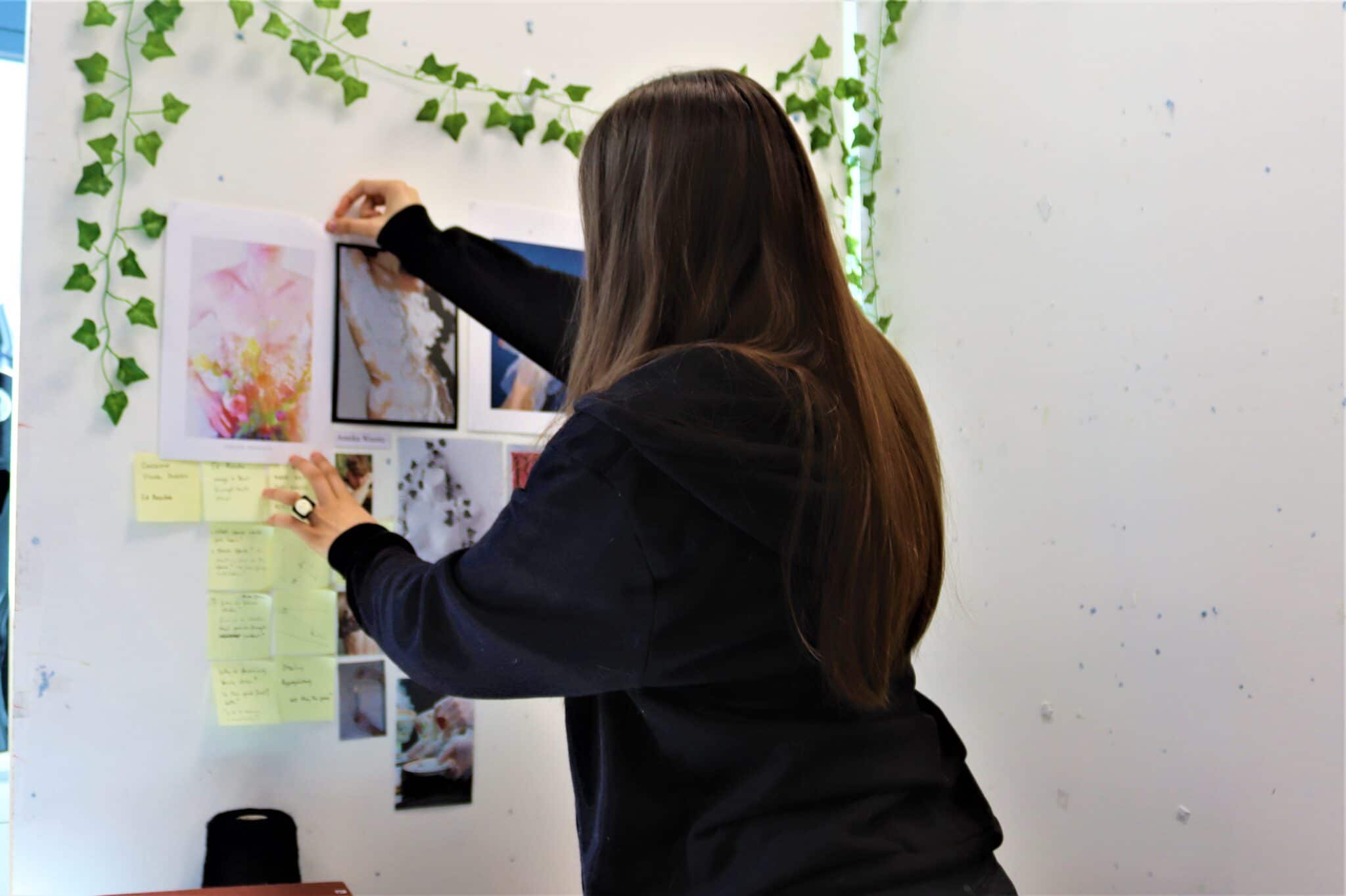 Evie putting up art