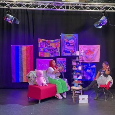 Becca & Sam talking on a set in a studio