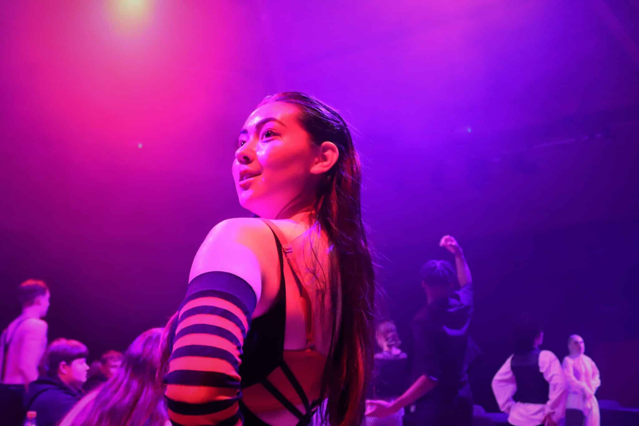Student in pink and purple light in cabaret
