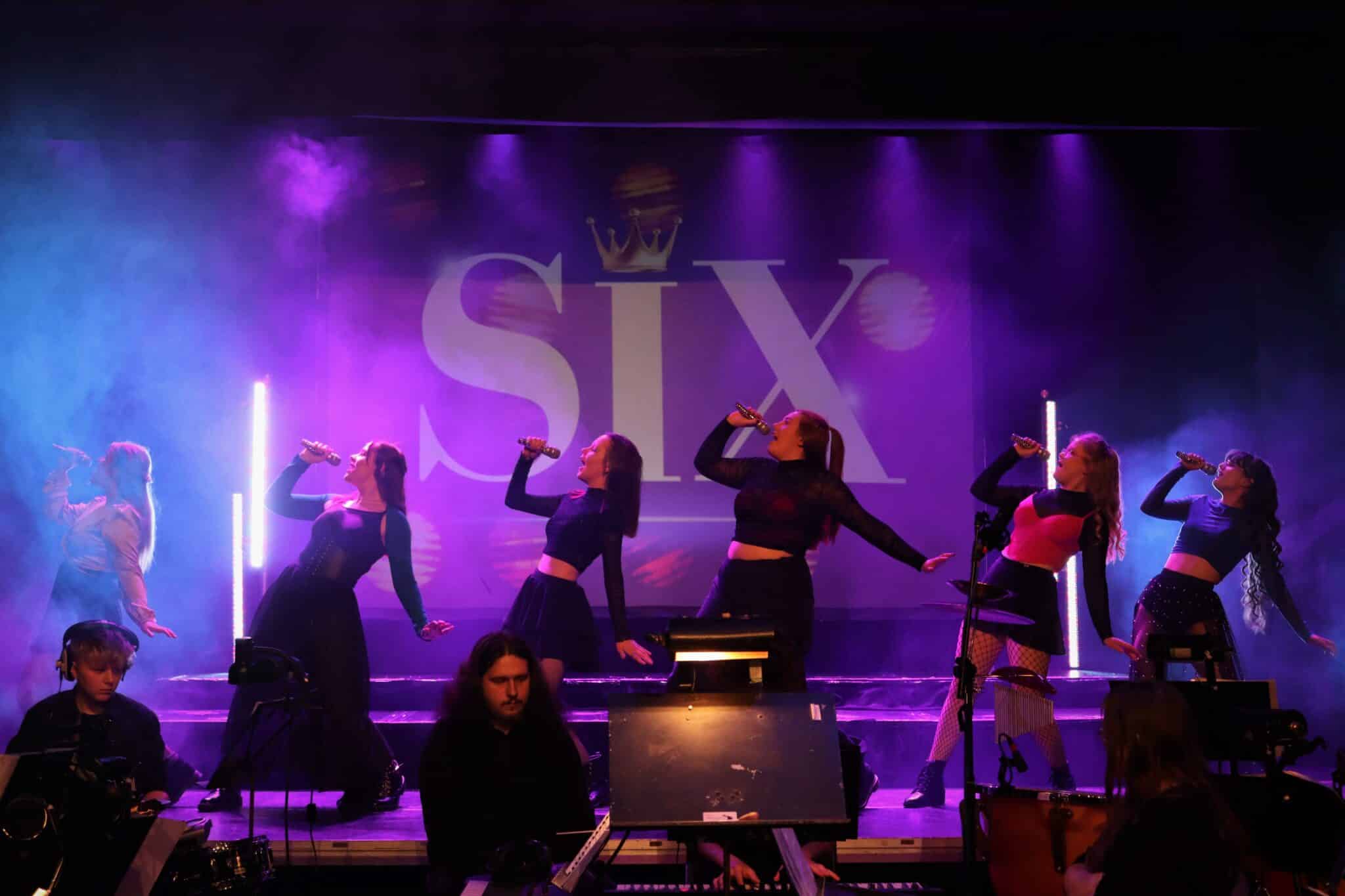 Six students perform on-stage.