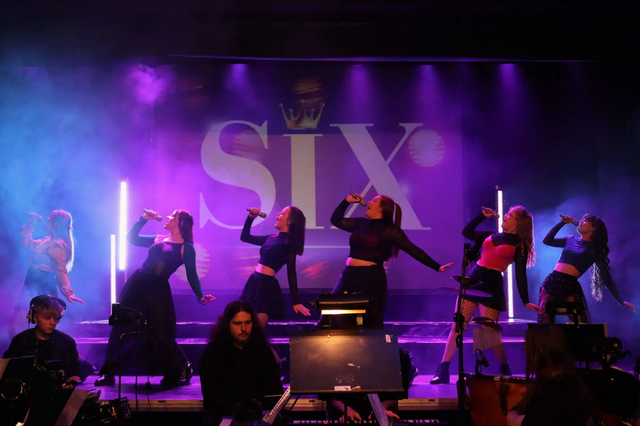 Six students perform on-stage.