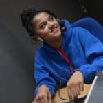Media student operating a mixing board in a television studio gallery at Stratford-upon-Avon College.
