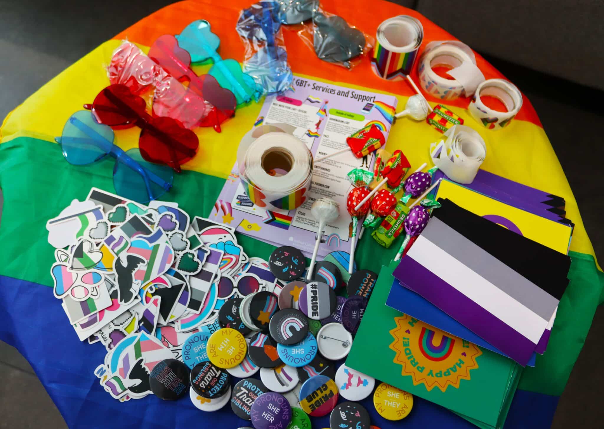 College celebrates Pride Month - table with fun sunglasses, stickers and more