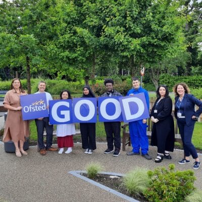students and staff with signs reading GOOD