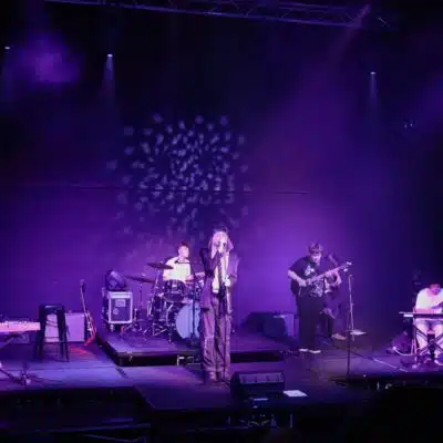 Stratford College Students perform a concert on a stage under purple lights