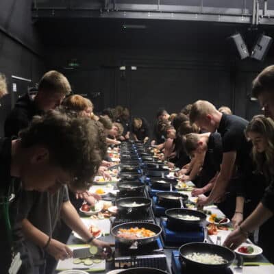 Students stood in a group cooking food