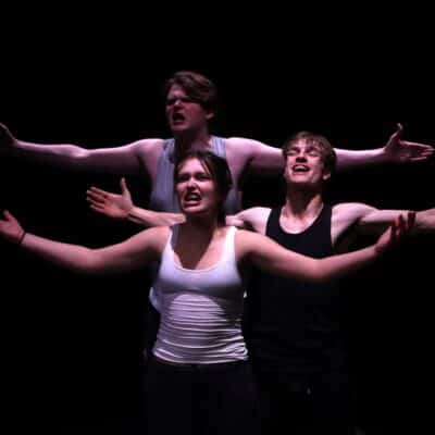 3 students holding their hands out