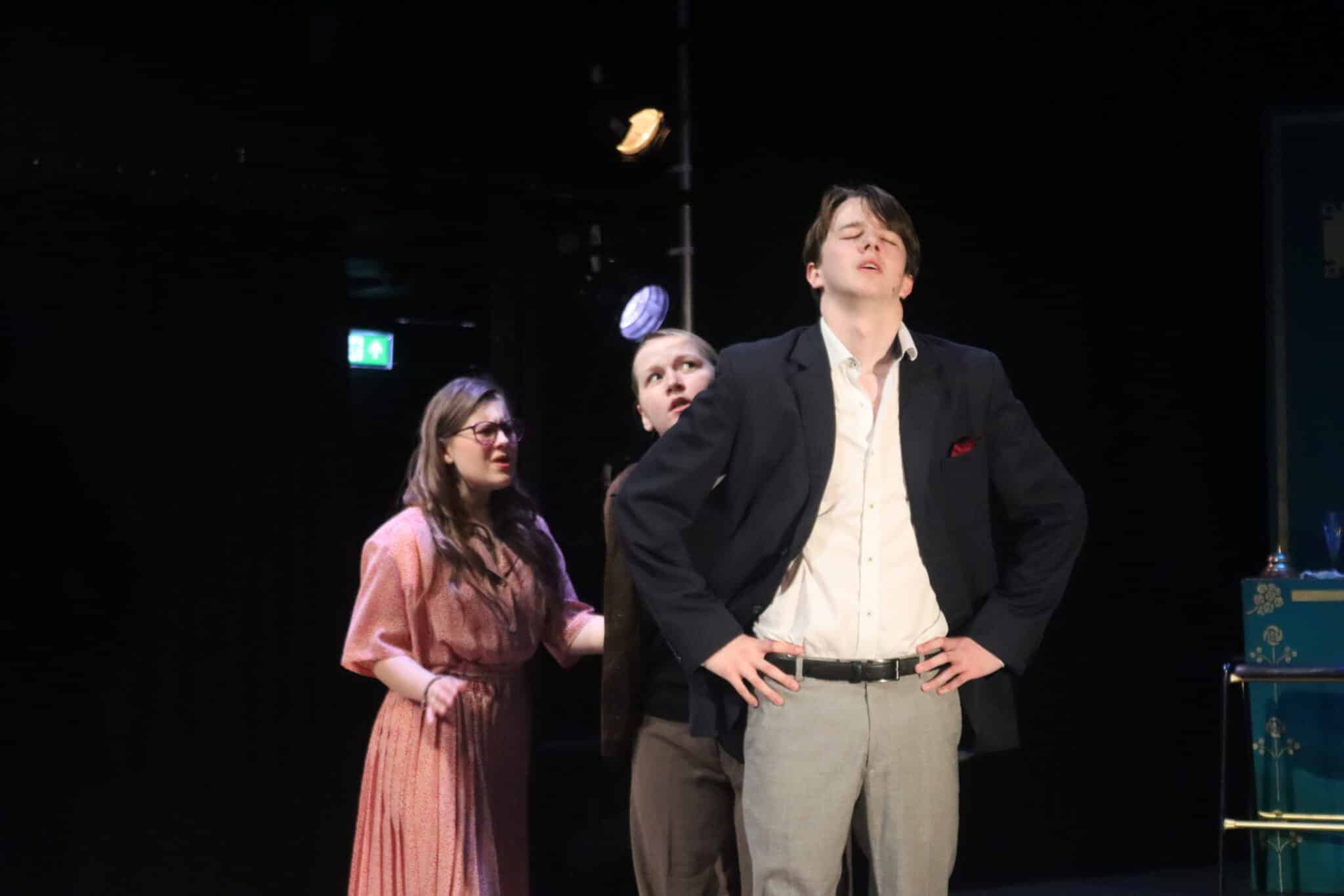 A man and two women on stage