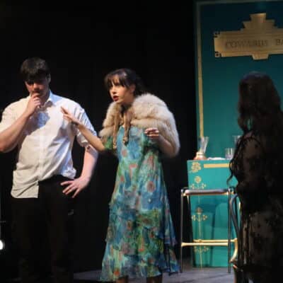 Three actors looking shocked on stage