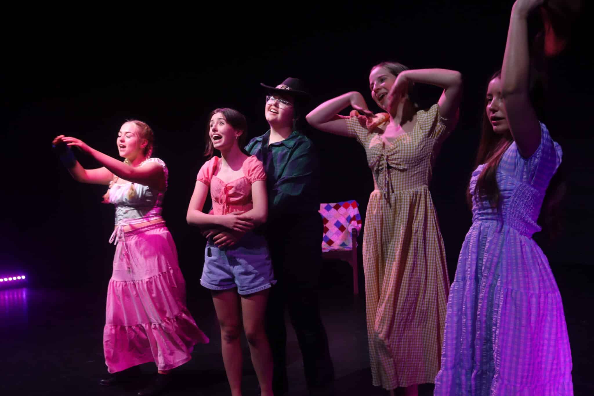 5 students singing on stage