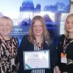 3 women smiling holding a certificate