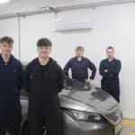 4 student stood in front of electric vehicle