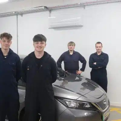 4 student stood in front of electric vehicle