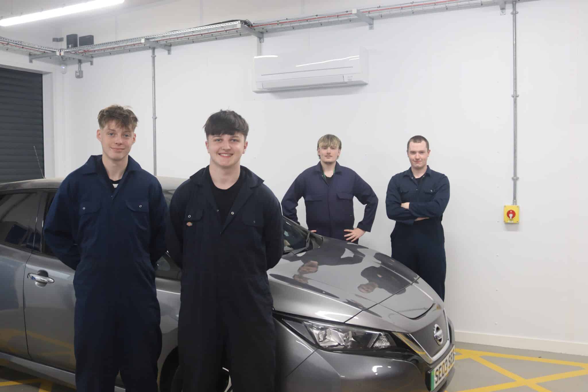 4 student stood in front of electric vehicle