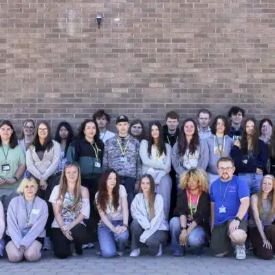 Students stood in front of a brick wall.
