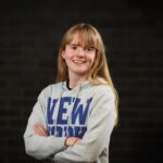 Girl in graphic jumper smiling at camera