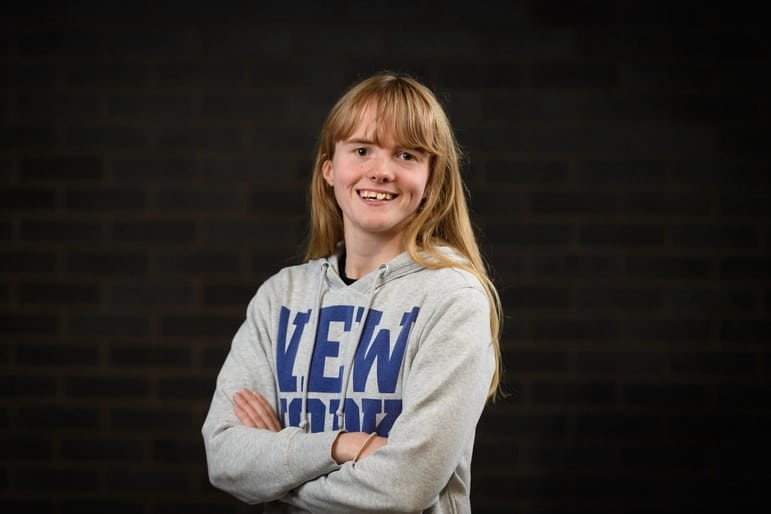 Girl in graphic jumper smiling at camera