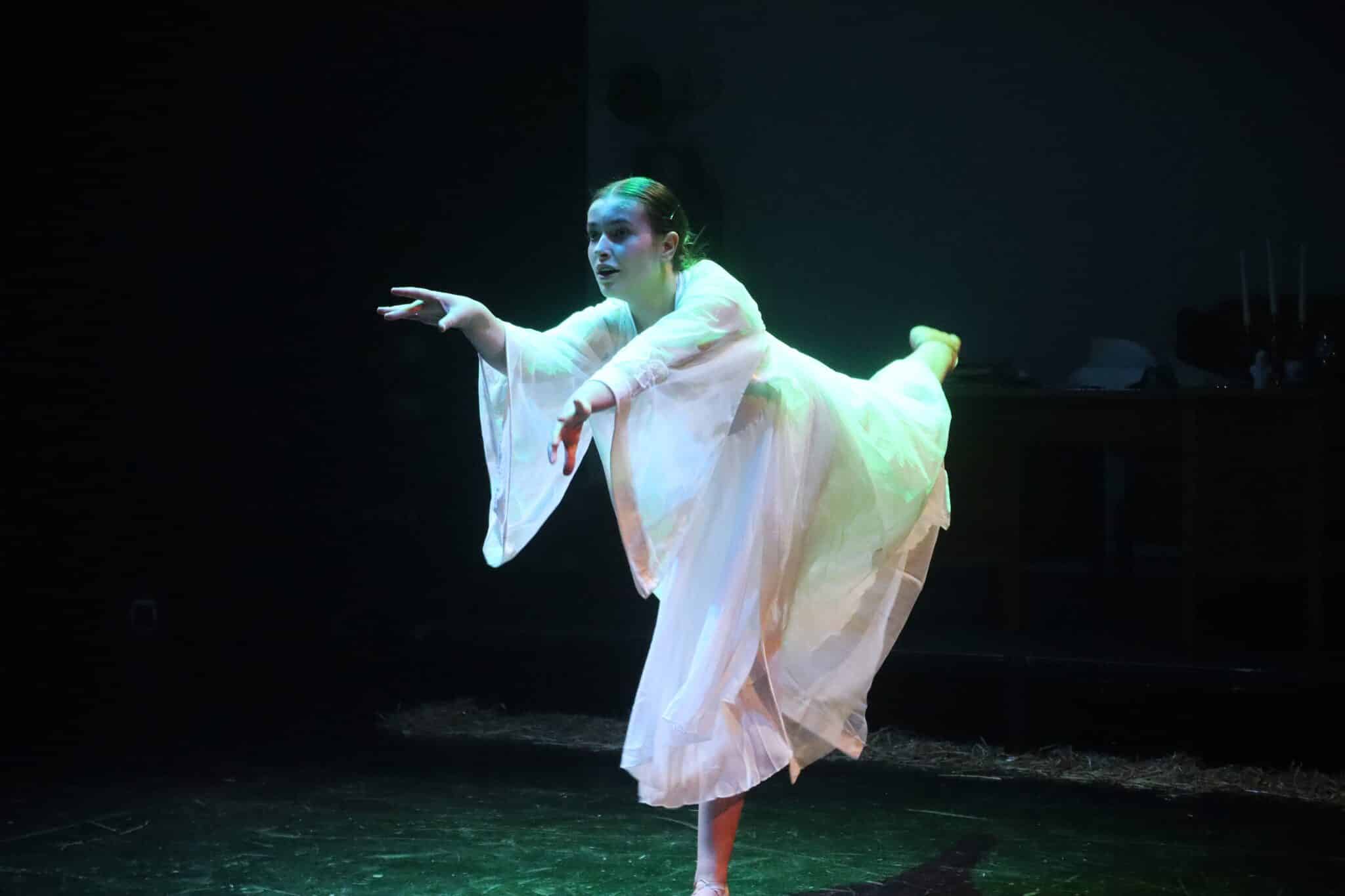 student in white dress dancing