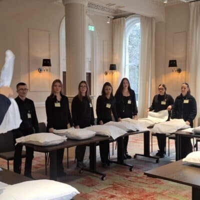 students behind tables with linen on tblae infront