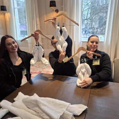 students showing off their linen creations on hangers