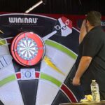 student throwing dart at dartboard