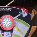 student throwing dart at dartboard