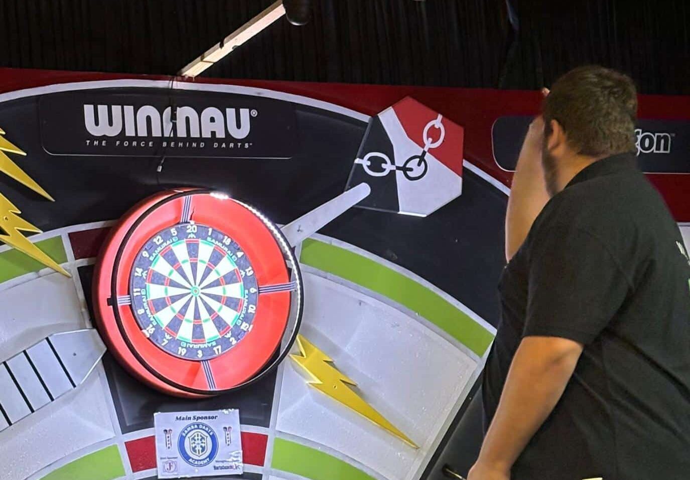student throwing dart at dartboard