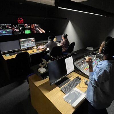 a woman looking at screens in the editing studio