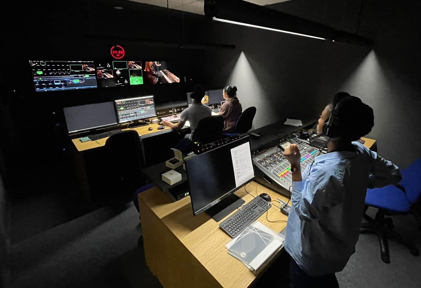 a woman looking at screens in the editing studio